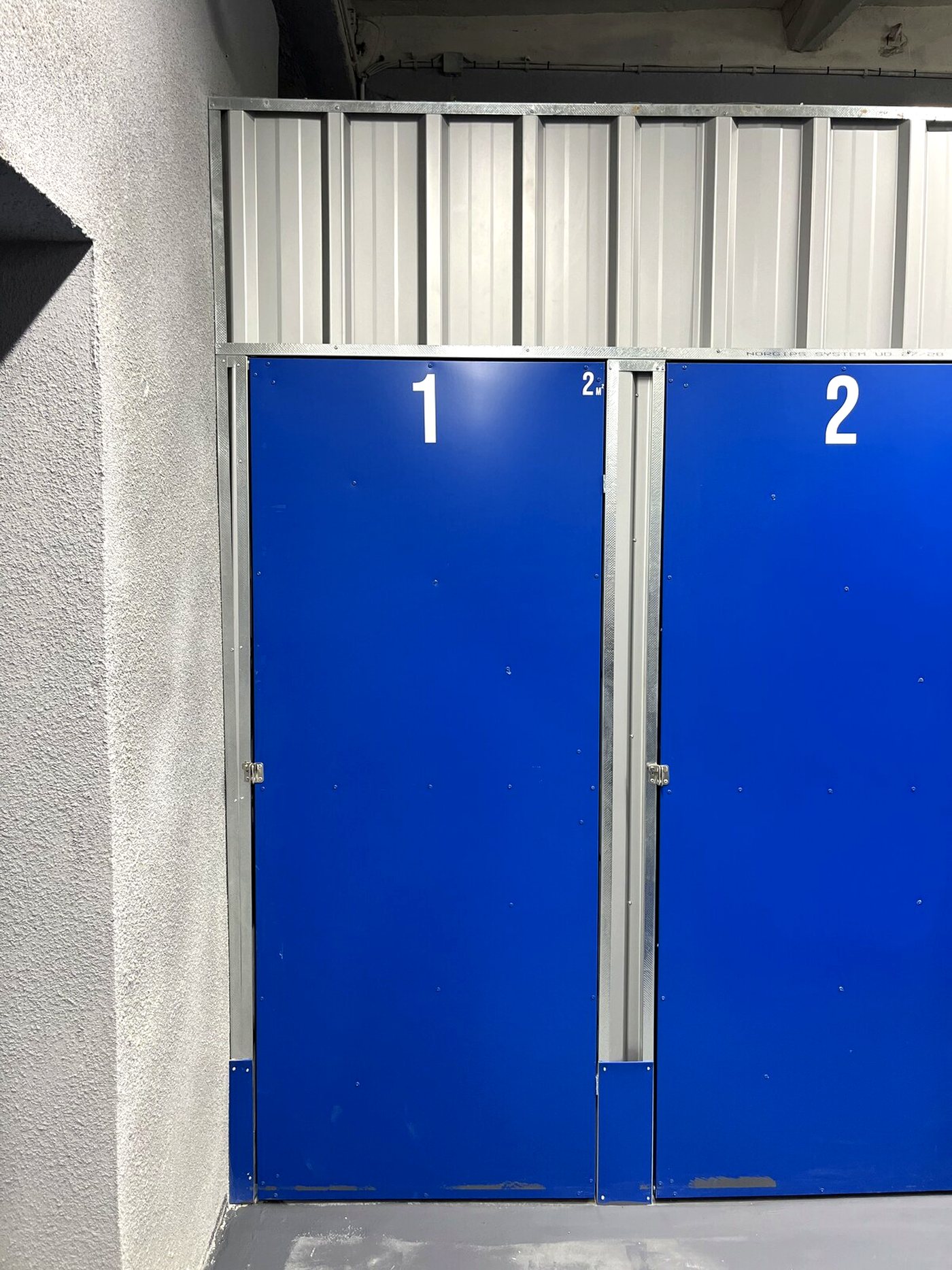 Ponumerowane drzwi boksów magazynowych
